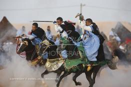 Image du Maroc Professionnelle de  Course typiquement marocaine dite ''la Fantasia'' organisé dans un site désertique sur lequel la ville de Tan Tan a toujours accueilli la majorité des tribus et des grandes familles nomades du désert lors d'un grand Moussem, Samedi 7 Septembre 2013. Le festival parrainé par l'UNESCO rassemble des milliers de nomades du Maroc. (Photo / Abdeljalil Bounhar) 